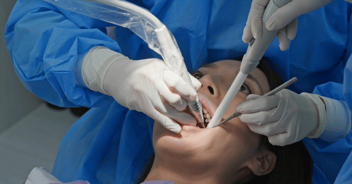 A dental team performing scaling and root planing treatment on a patient to treat gum disease.