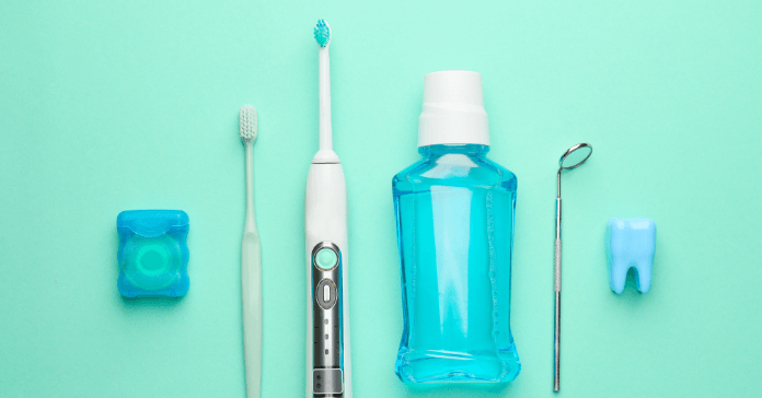 A collection of oral hygiene products including a toothbrush, electric toothbrush, mouthwash, floss, dental mirror, and tooth model.