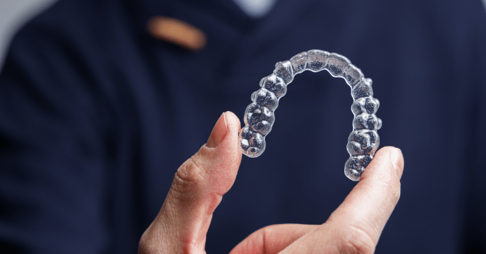 Clear aligner used for orthodontic treatment to straighten teeth.