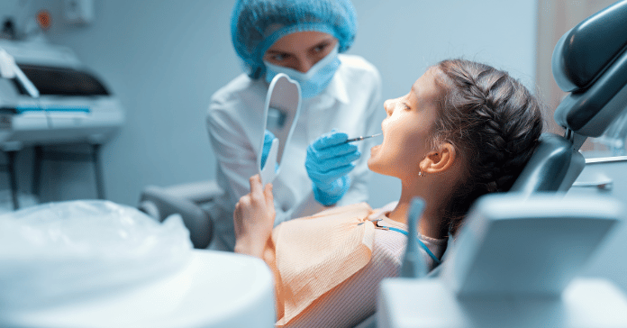 Pediatric dentist examining a child during a dental checkup.