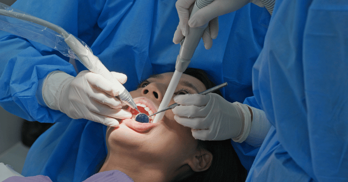Dentist performing professional dental cleaning and scaling on a patient.