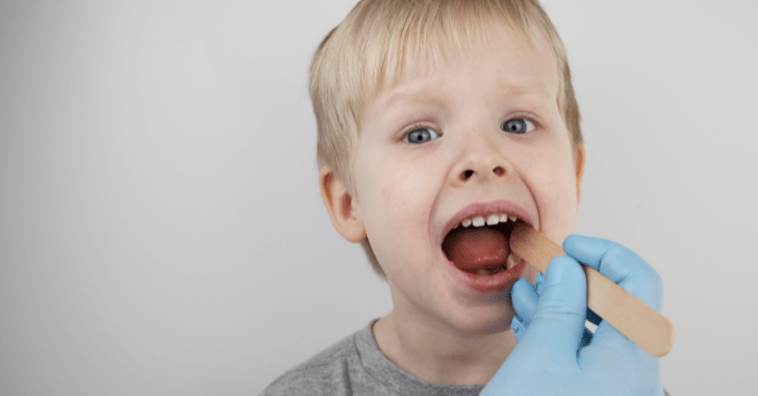 Pediatric dentist examining a young child’s mouth during a dental checkup.